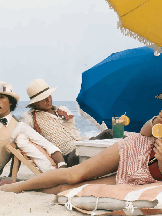Photo of Antonio Lopez, Corey Tippin, and Donna Jordan, St.-Tropez, 1970 laying on the sand with drinks and beach umbrella